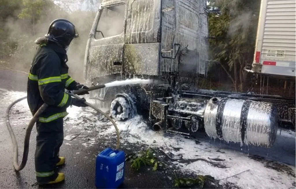 Galão azul de líquido gerador de espuma LGE AFFF conectado a mangueira de caminhão de bombeiros em operação